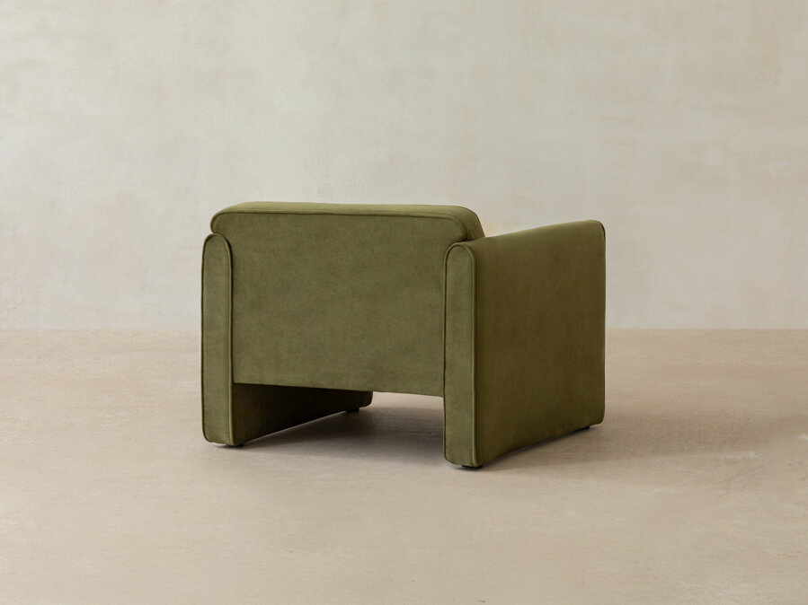 Kreslo Abby v zamatovom čalúnením zelenej farby a pohľad na jeho zadnú stranu.