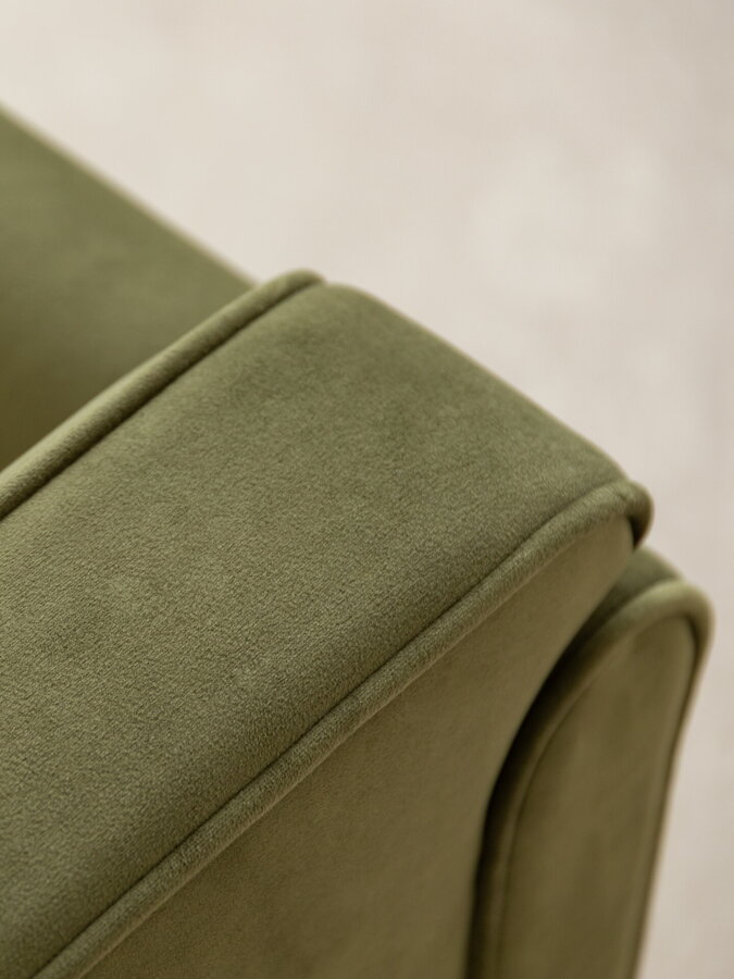 Detail na opierku zeleného čalúneného kresla.