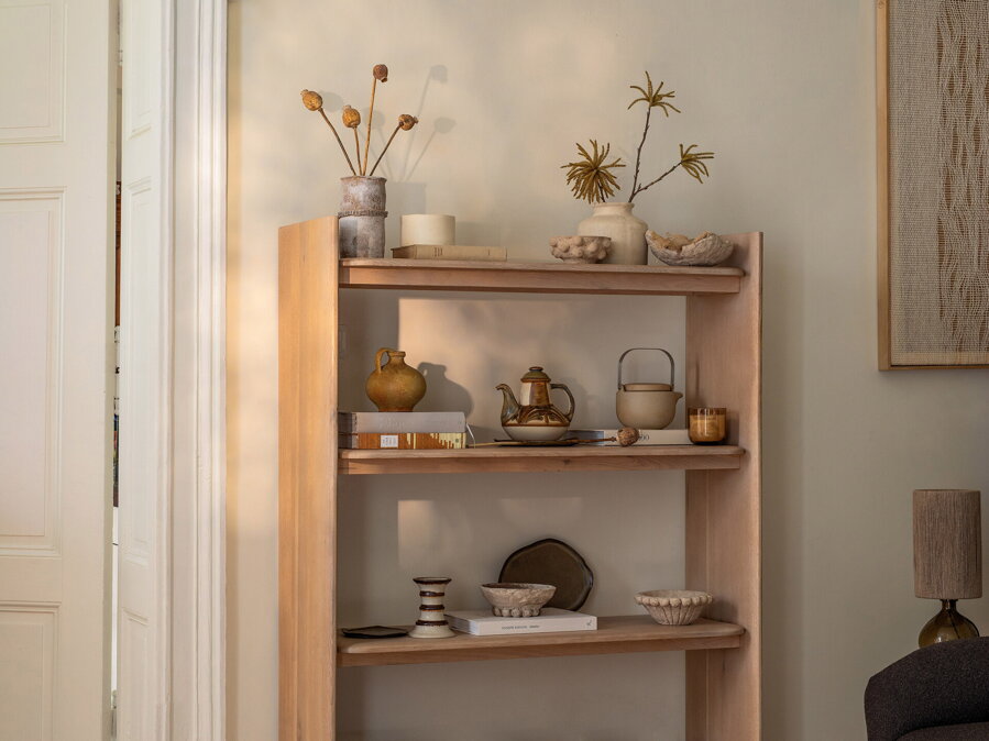 Dubová knižnica so štyrmi policami, na ktorých sú rôzne dekoračné predmety.