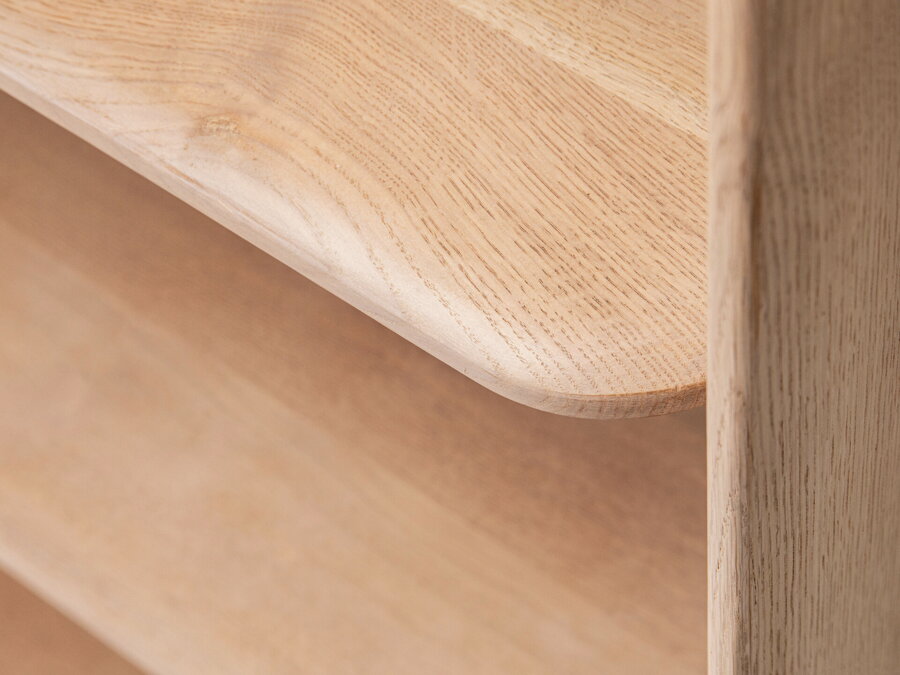 Zaoblená polica dubovej knižnice v prírodnej farbe.