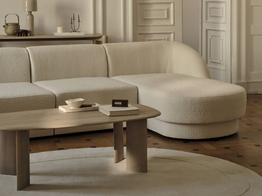 Obdĺžnikový konferenčný stolík Aggie z dubového dreva prírodnej farby v obývačke s bielou rohovou sedačkou.