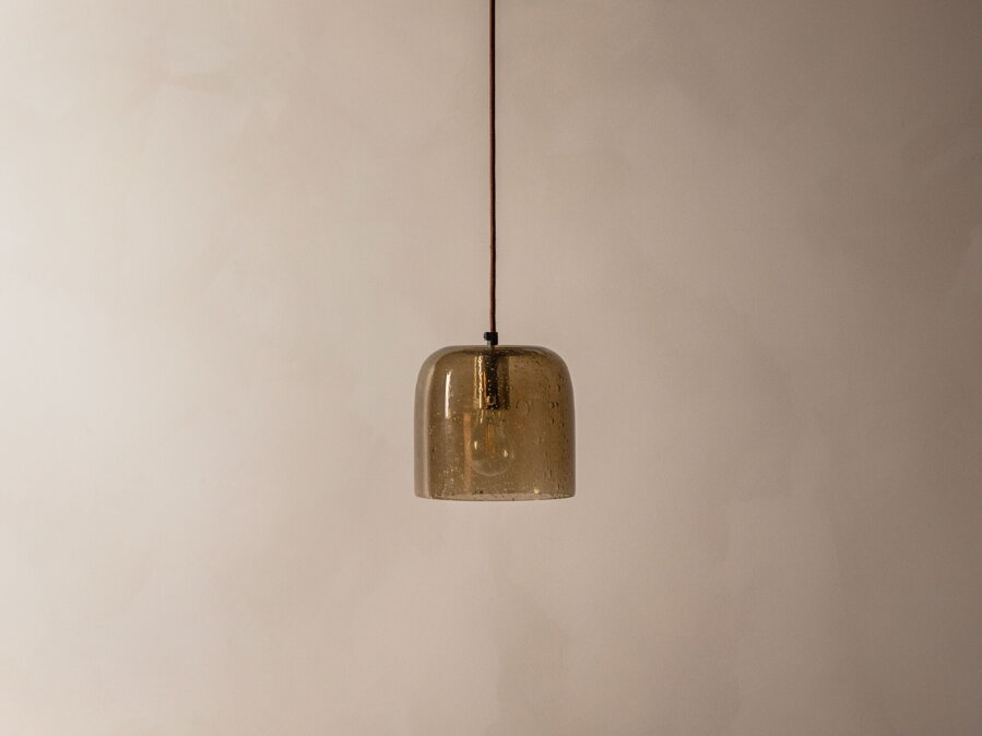 Závesná lampa Aura s tienidlom z  bublinkového skla jantárovej farby.