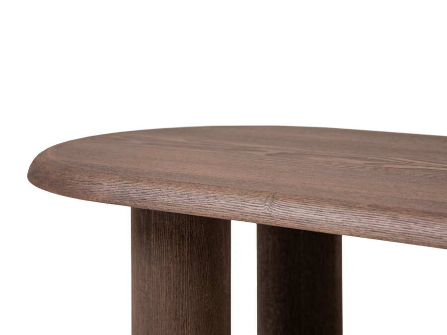 Detail na nohy a oválnu stolovú dosku tmavohnedého konferenčného stolíka.