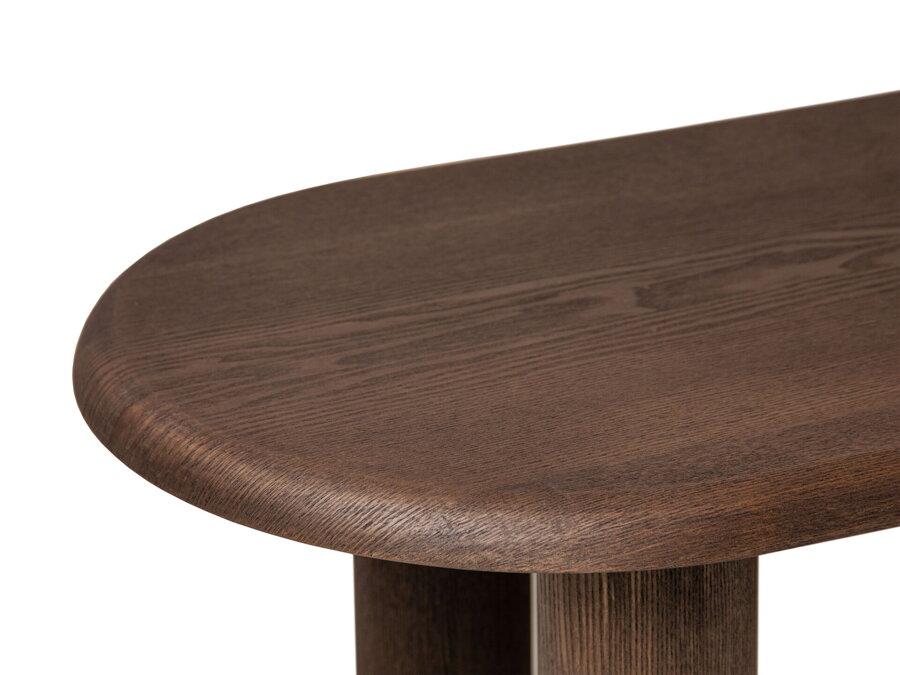 Detail na oblú hranu stolovej dosky tmavohnedého konferenčného stolíka.