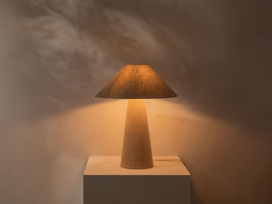 Zasvietená stolová lampa Dione z ľanovej tkaniny prírodnej farby.