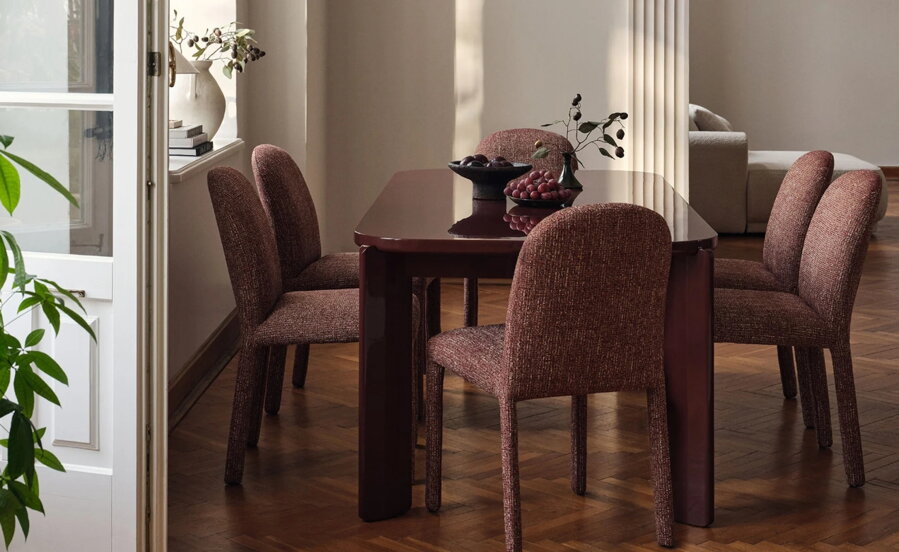 Červené celočalúnené jedálenské stoličky za jedálenským stolom v jedálni.