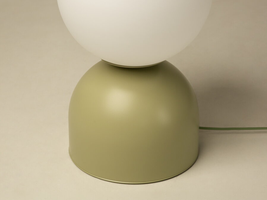 Detail na matnú svetlozelenú kovovú základnňu lampy Ely.