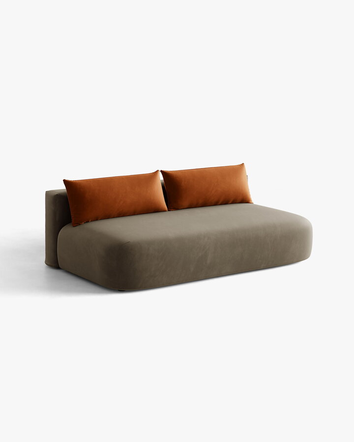 Pohovka Hena v čalúnení Velvet (Salvador) v sivohnedom odtieni s oranžovými vankúšmi.