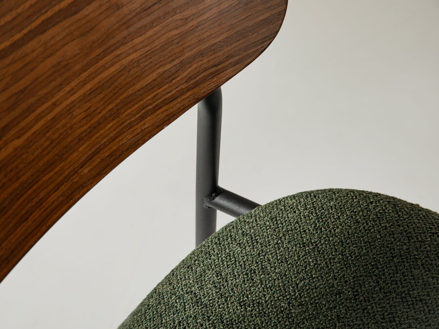 Jedálenská stolička Hestia so zeleným čalúnením sedákom, operadlom z preglejky a čiernymi kovovými nohami..