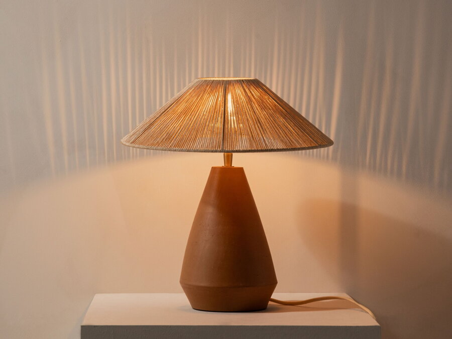 Svietiaca stolová lampa s terakotovou základňou a tienidlom z viskózového povrazu.