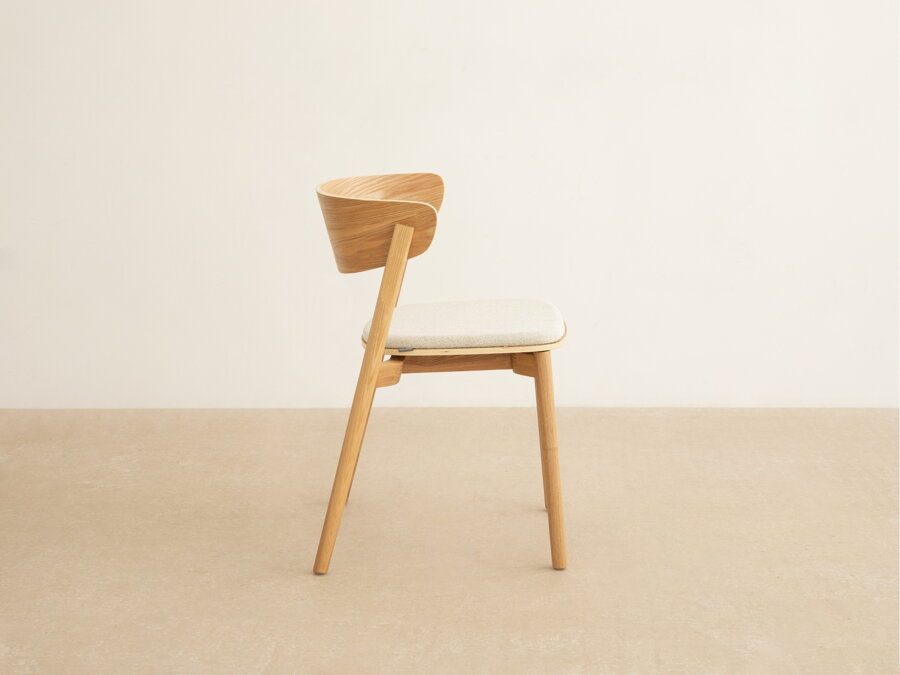 Jedálenská stolička Mares z masívneho jaseňového dreva prírodnej farby a sedákom v béžovom čalúnení a pohľad z boku.