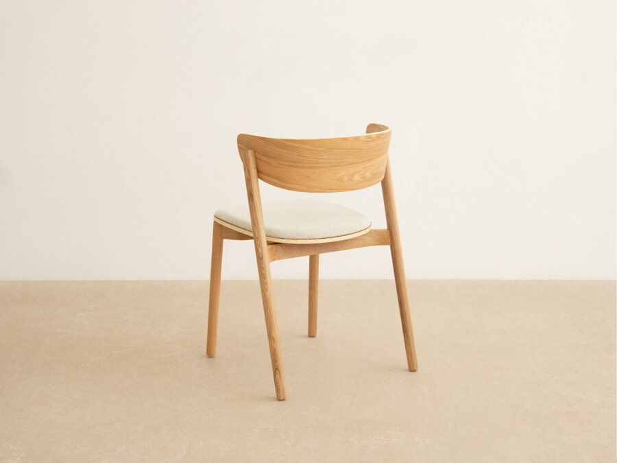 Minimalistická jedálenská stolička Mares z masívneho jaseňového dreva prírodnej farby a sedákom v béžovom čalúnení a pohľad zo zadu.