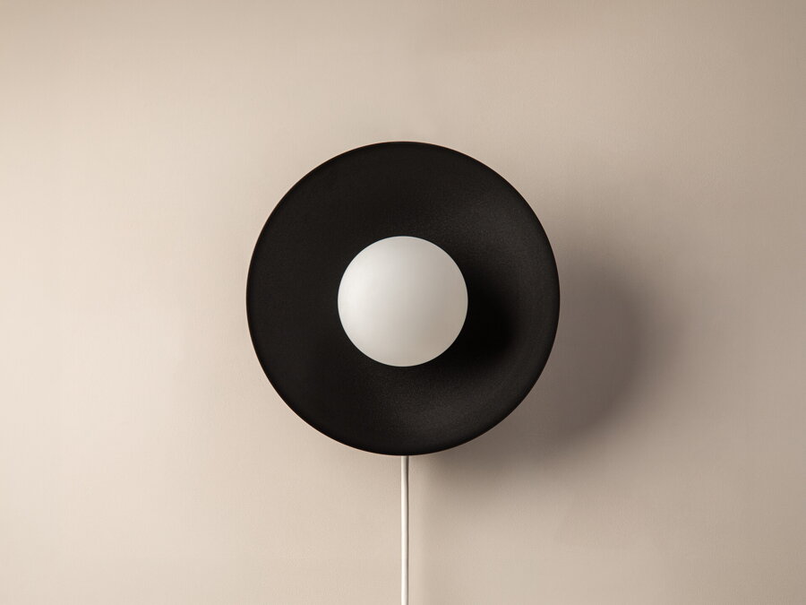 Nástenná lampa Mist, ktorá spája okrúhly kovový rám čiernej farby s matnou bielou sklenenou guľou
