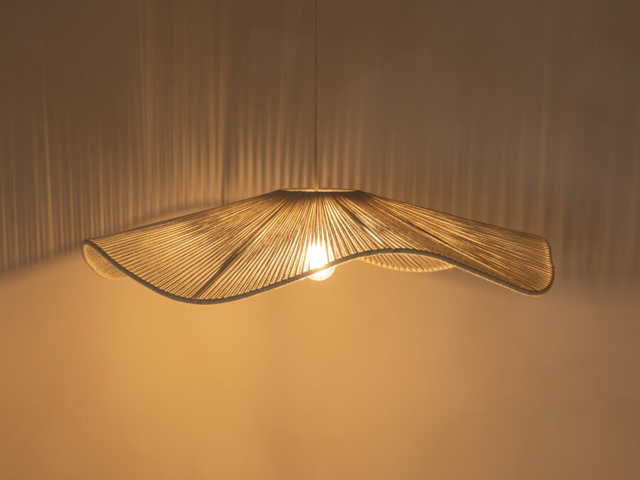 Svietiaca biela závesná lampa v prítmí.