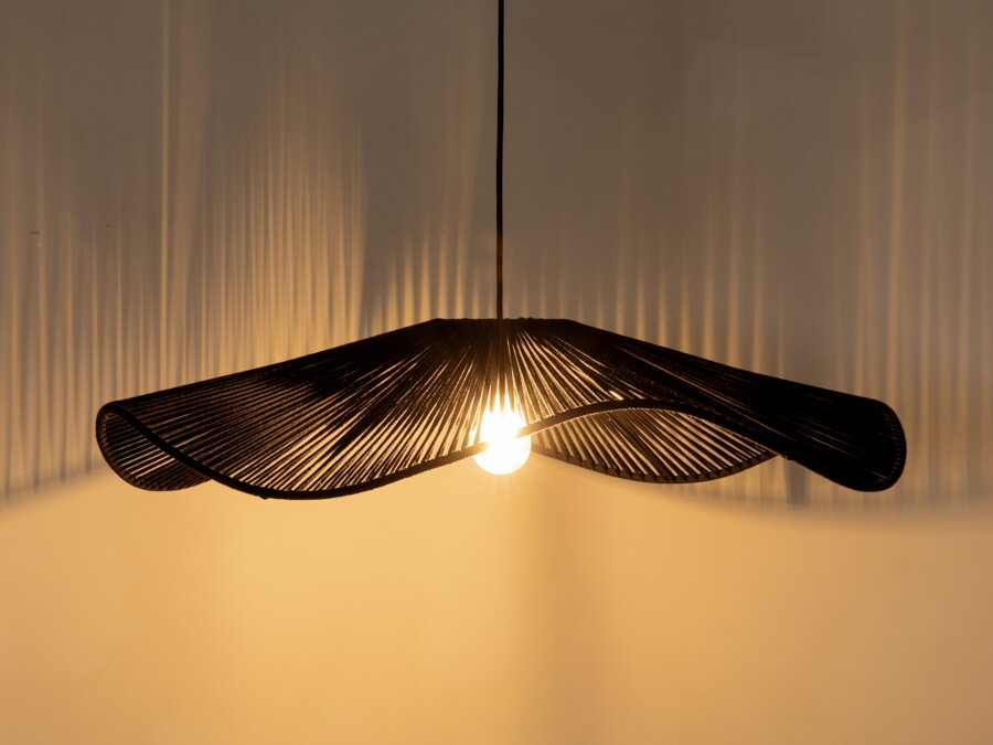 Svietiaca čierna závesná lampa v prítmí.