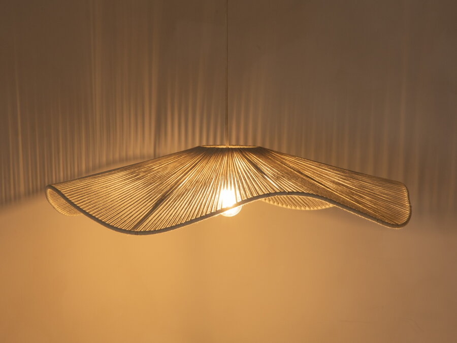 Svietiaca biela závesná lampa v prítmí.