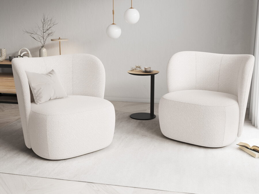 Dve svetlé béžové kreslá na bielej podlahe, medzi ktorými je čierny príručný stolík.