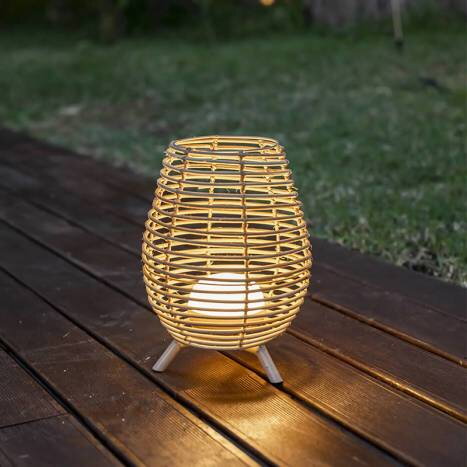 Bezdrôtová ratanová lampa položená na záhradnej terase