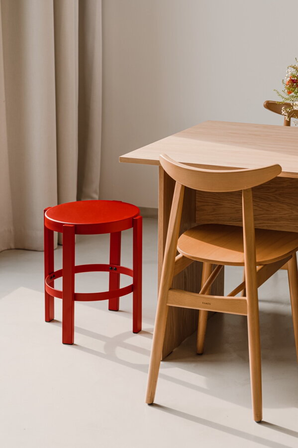 Červený stolík/stolička Doon z robustnej práškovanej ocele v jedálni vedľa jedálenského stola so stoličkami.