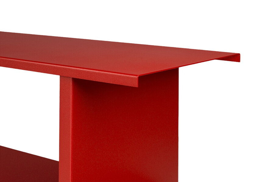 Detail na matný povrch červenej police z práškovanej ocele.