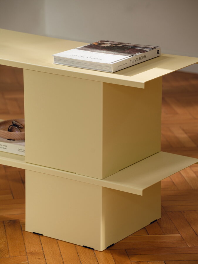 Dizajnová polica Hes z práškovanej ocele svetložltej farby.