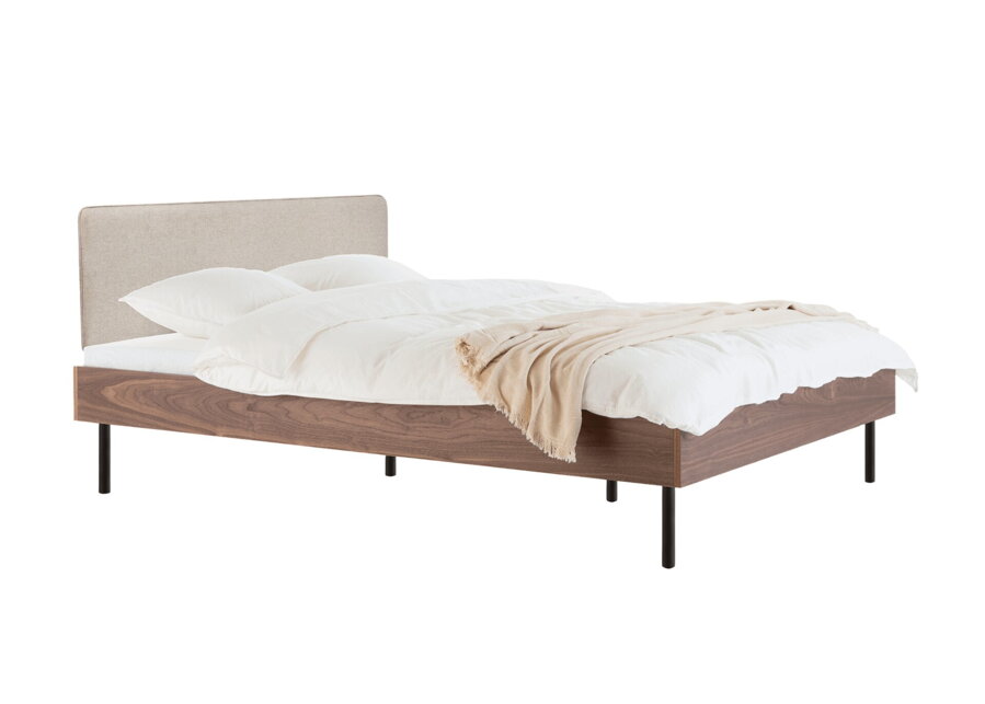 Posteľ Streiko z orechovej dyhy prírodnej farby s čalúneným čalom v odtieni pieskovom.