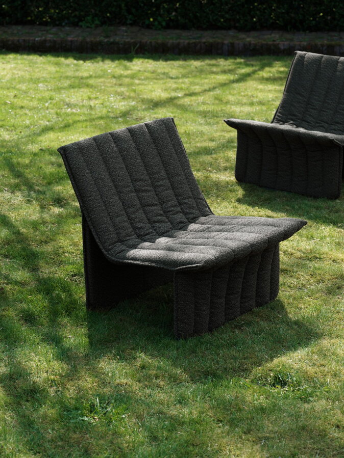 Dve tmavosivé záhradné kreslá na záhrade.