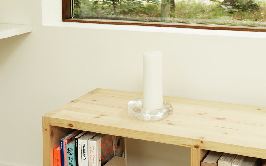 Svietnik Odd položený na knižnici z borovicového dreva. 