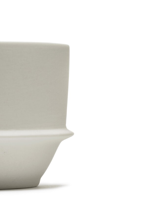 Detail na vonkajší matný povrch porcelánovej šálky na kávu/čaj v sivobielej farbe
